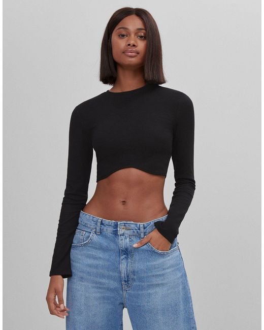 Crop top a maniche lunghe con fondo sagomato di Bershka in Black