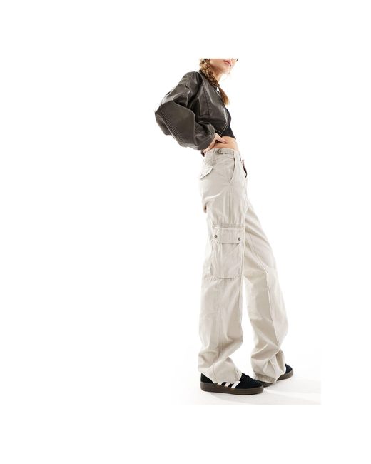 Pantaloni cargo multitasche a vita bassa color sabbia di Bershka in White