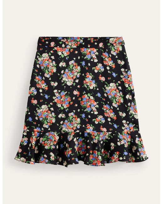 Mini-jupe florale à volants en satin Boden en coloris Black