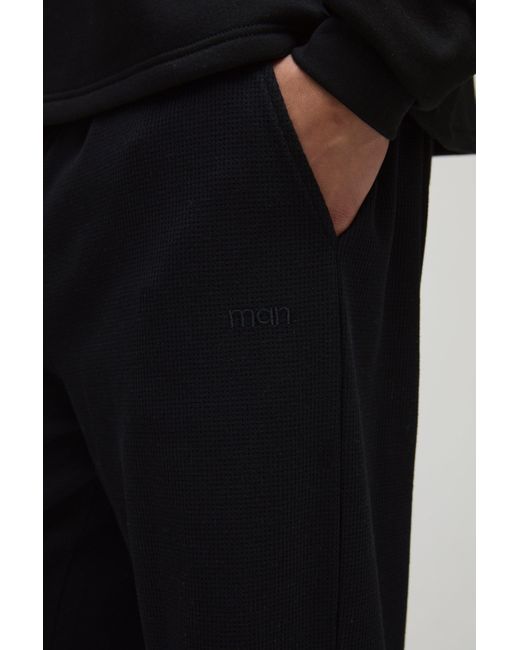 BoohooMAN Jogginghose mit geradem Bein in Waffeloptik und Man-Stickerei in Black für Herren