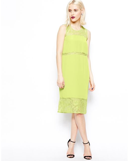 Lime midi dress Dress features an asymmetric draped panel that sits over the left shoulder. The upper of the dress sits quite open through the bust area. The lower of the dress is a fitted midi with a back split.