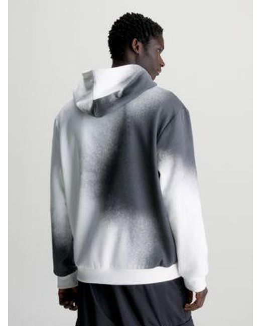 Sudadera holgada con capucha y logo estampado de spray Calvin Klein de hombre de color White