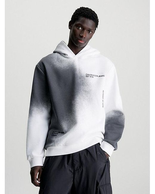 Sudadera holgada con capucha y logo estampado de spray Calvin Klein de hombre de color White