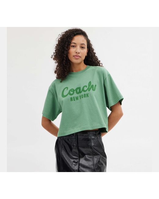 COACH Green Verkürztes T-Shirt mit kursiver Signature