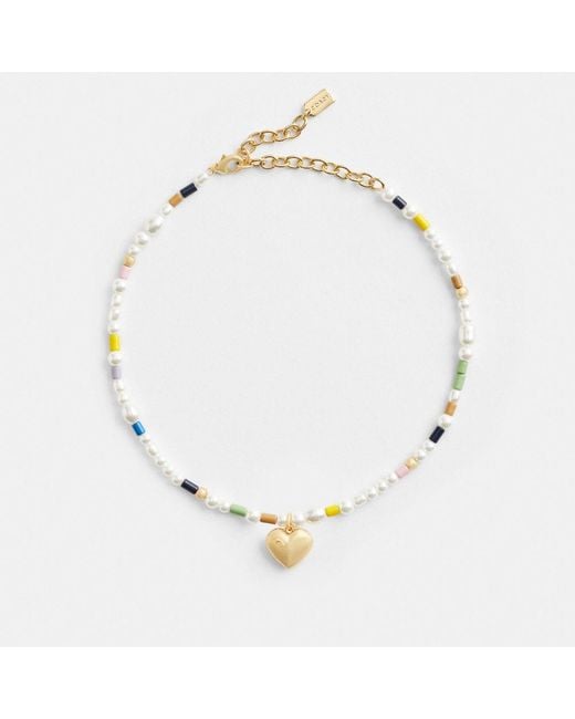 Collier ras-du-cou avec perles et cœur signature COACH en coloris Metallic