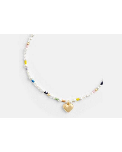 Collier ras-du-cou avec perles et cœur signature COACH en coloris Metallic