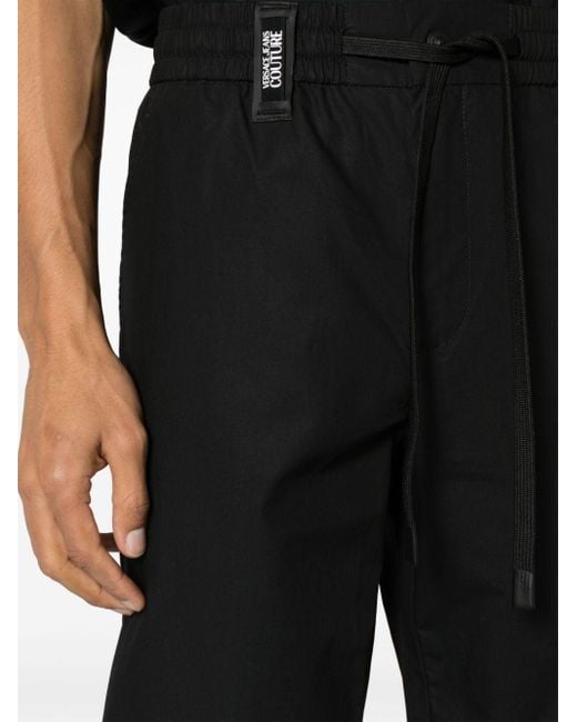 Pantalones ajustados con tira del logo Versace de hombre de color Black