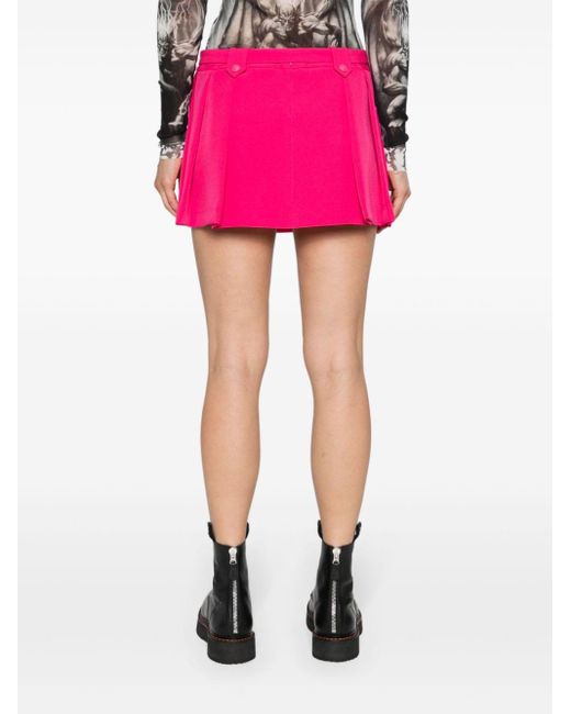 Minifalda plisada de talle bajo Versace de color Pink