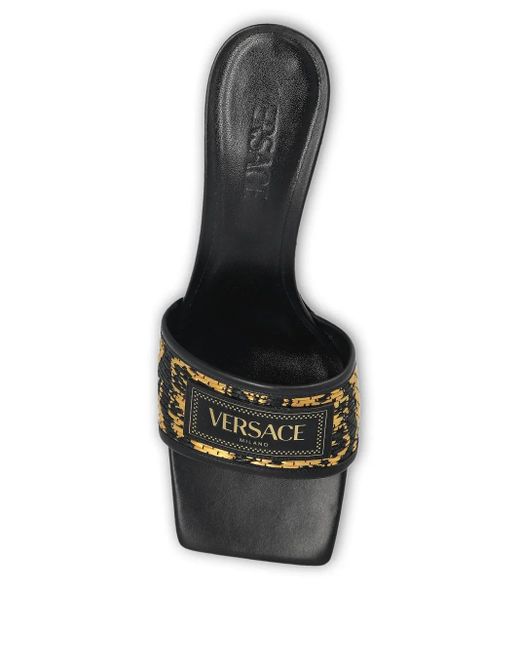 Mules Theia Barocco con tacón de 55 mm Versace de color Black