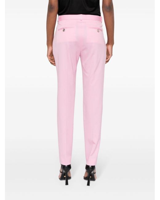 Pantalon fuselé à plis marqués Versace en coloris Pink