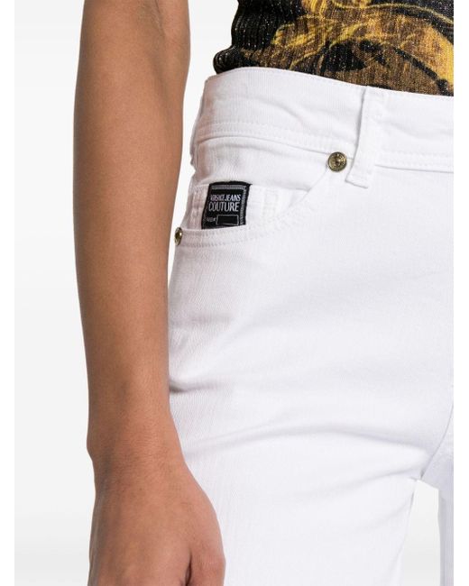 Jeans a gamba ampia con applicazione di Versace in White
