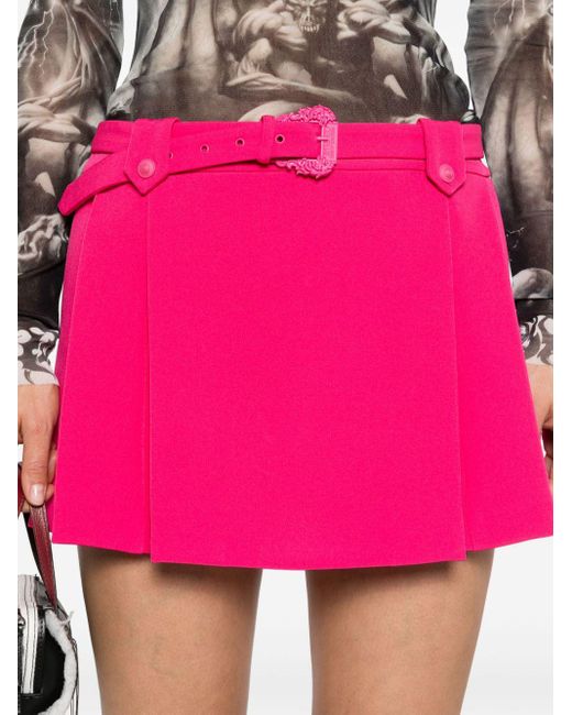 Minifalda plisada de talle bajo Versace de color Pink