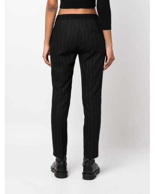 Pantaloni slim gessati di Versace in Black