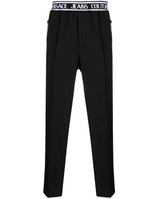 Pantaloni slim con banda logo di Versace in Black da Uomo