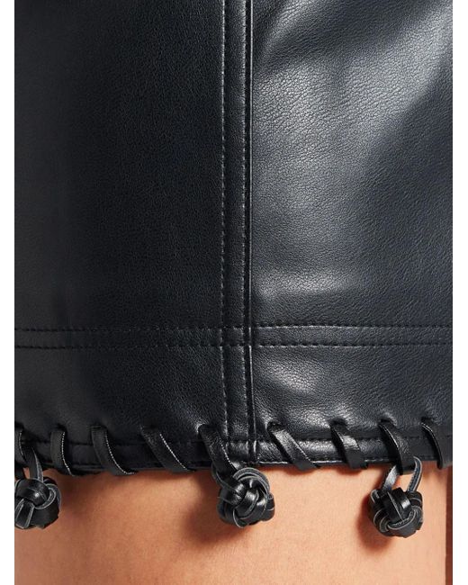 Falda corta con detalle de nudo Aje. de color Black