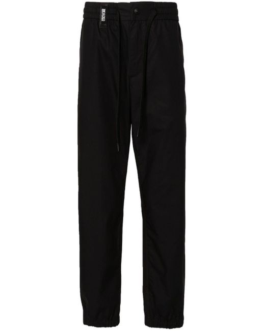 Pantalones ajustados con tira del logo Versace de hombre de color Black