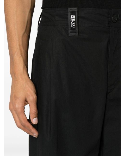 Pantaloni a gamba ampia crop di Versace in Black da Uomo