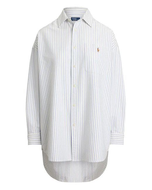 Customer holding up a Polo Ralph Lauren shirt in a store trying on