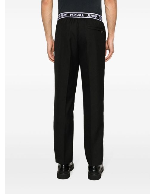 Pantalones slim con logo en la cinturilla Versace de hombre de color Black