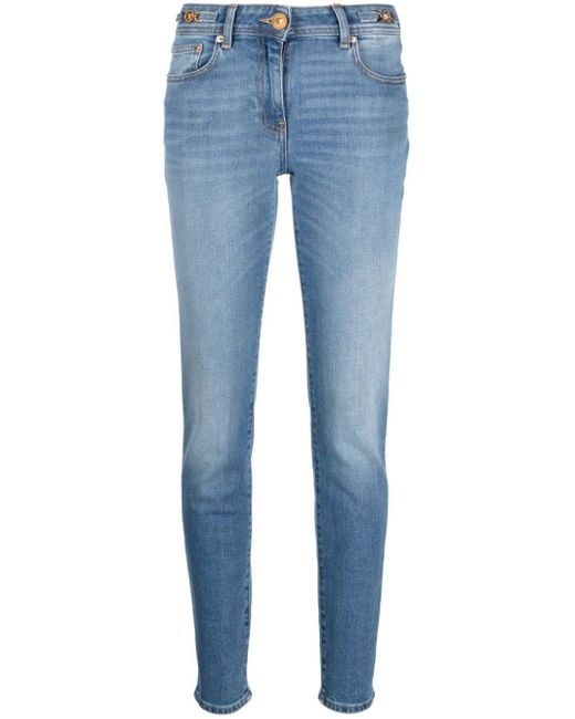 Jean skinny à taille basse Versace en coloris Blue