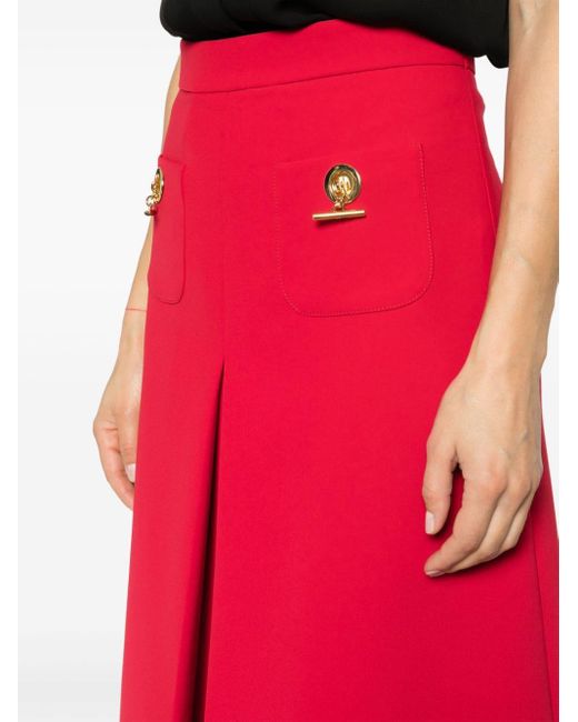 Jupe mi-longue évasée à design plissé Moschino en coloris Red