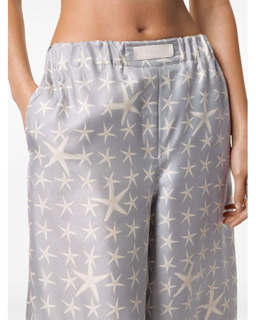 Pantalones fluidos con estampado de estrellas de mar Versace de color White