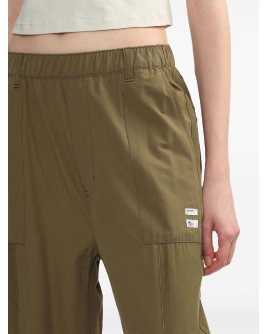 Pantalon de jogging à logo imprimé Izzue en coloris Green