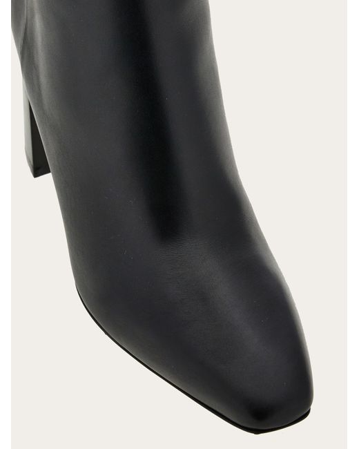 Knee high boot with golden tab Ferragamo en coloris Black