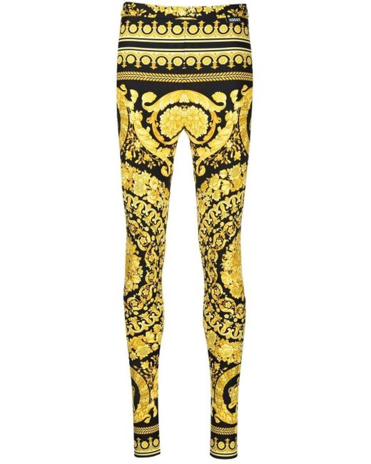 Leggings in tessuto stretch oro e nero con stampa baroque heriatge allover di Versace in Yellow