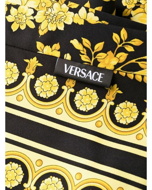 Leggings in tessuto stretch oro e nero con stampa baroque heriatge allover di Versace in Yellow