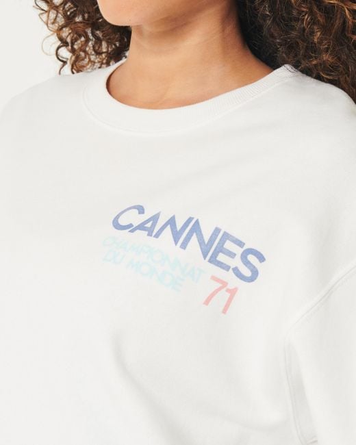 Hollister White Oversized-Sweatshirt mit Rundhalsausschnitt und Cannes Racing-Grafik.