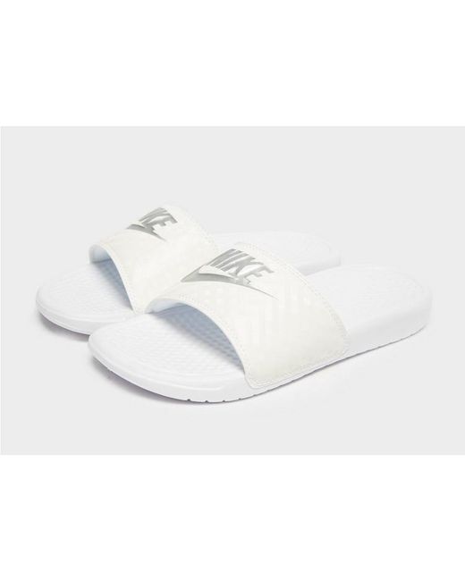 white and silver nike slides