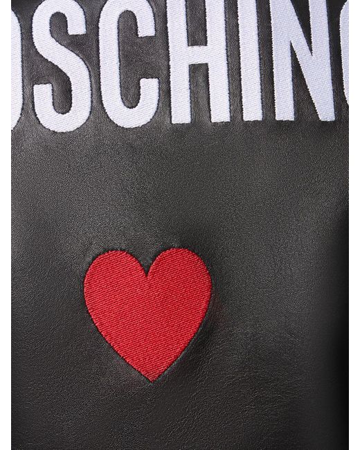 Giacca cropped in pelle con cintura e logo di Moschino in Black