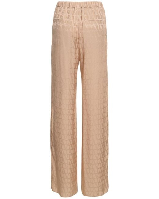Pantaloni dritti in seta jacquard con logo di Valentino in Natural