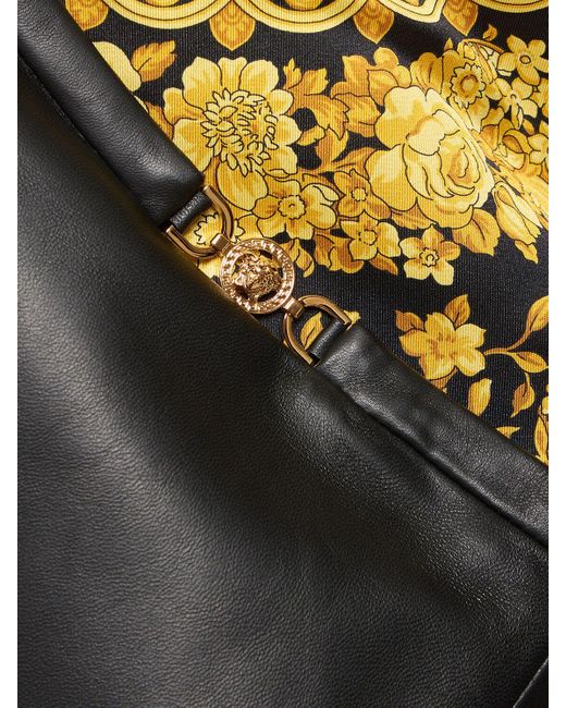 Jupe courte en cuir plongé à logo Versace en coloris Black