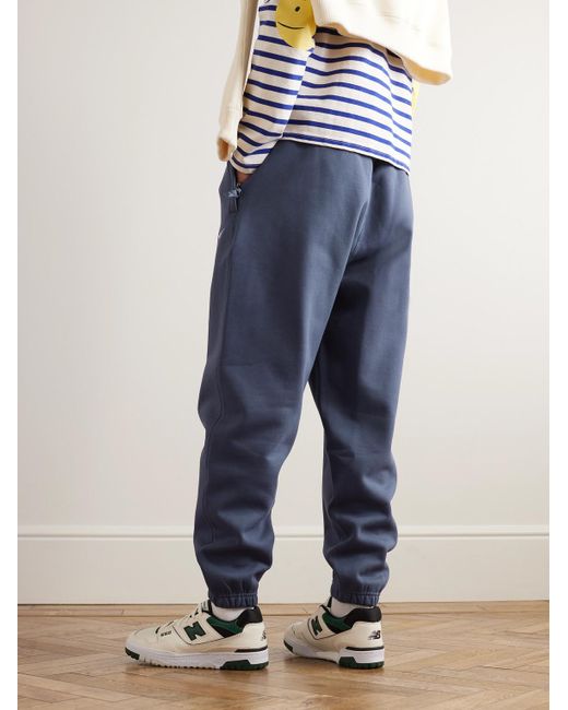 Pantaloni sportivi a gamba affusolata in jersey di misto cotone con logo ricamato Solo Swoosh di Nike in Blue da Uomo