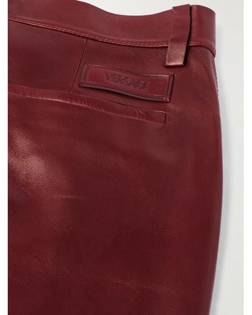 Pantaloni svasati slim-fit in pelle di Versace in Red da Uomo