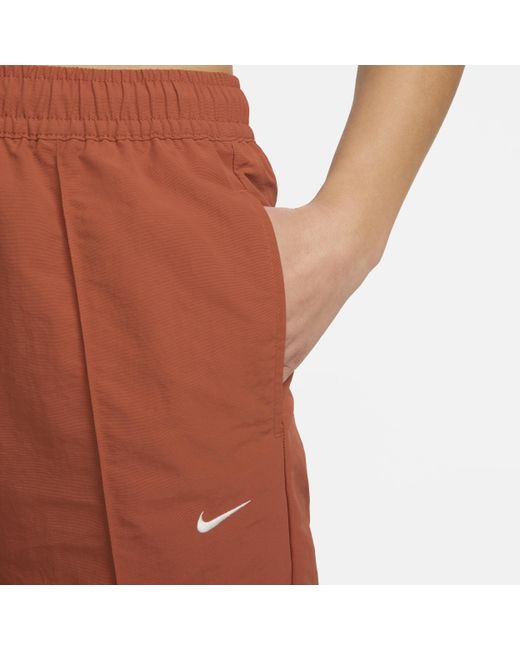 Pantaloni a vita media con bordo aperto sportswear everything wovens di Nike in Red
