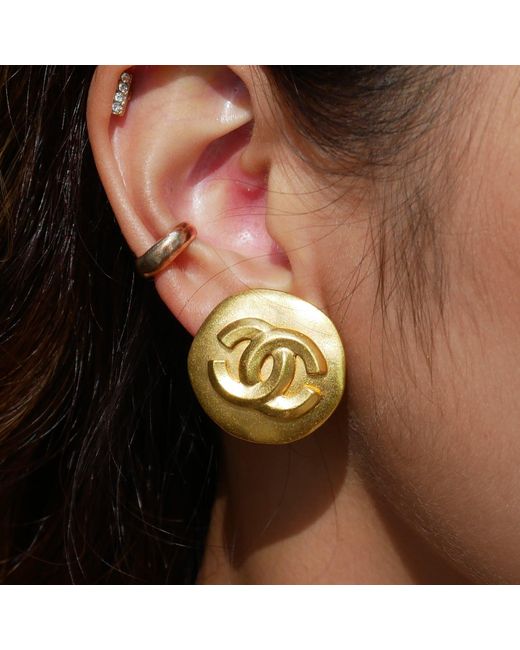 gold chanel earrings on ear