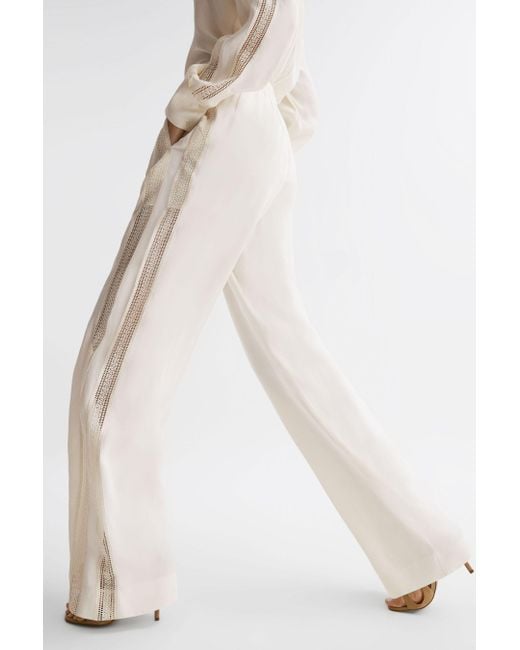 https://cdna.lystit.com/520/650/n/photos/reiss/207b7f5f/reiss-Cream-Rowan-Cream-Wide-Leg-Lace-Trousers.jpeg