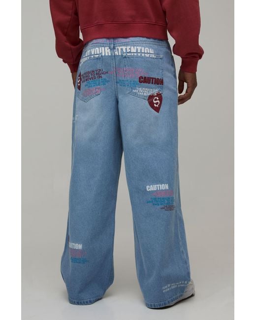 BoohooMAN Blue Caution All Over Graphic Tinted Baggy Fit Jeans for men