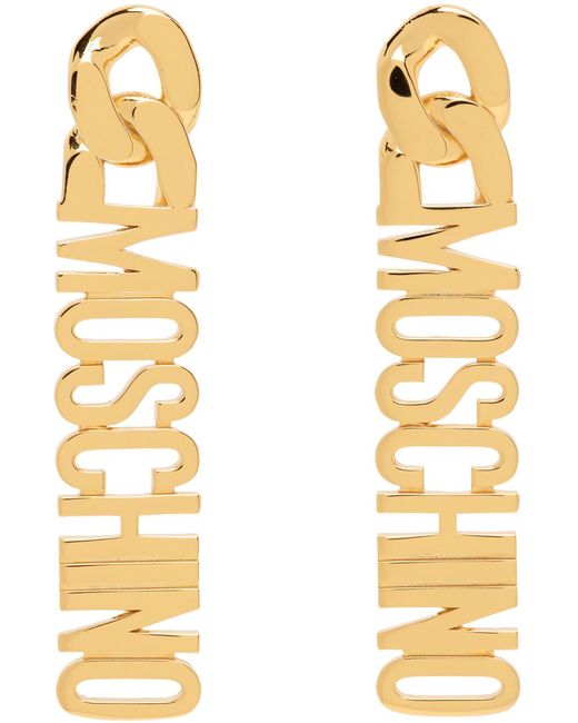 Boucles d'oreilles pendantes dorées à logo Moschino en coloris Metallic