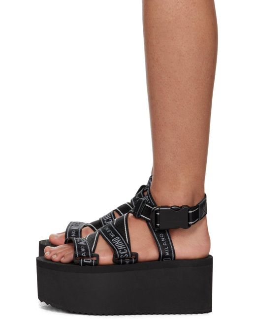 Sandales compensées noires à logos Moschino en coloris Black