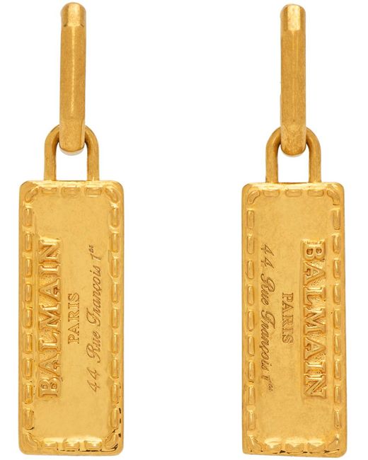 Boucles d'oreilles tubulaires dorées à plaque à logo Balmain en coloris Metallic