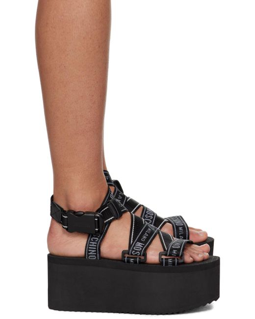 Sandales compensées noires à logos Moschino en coloris Black
