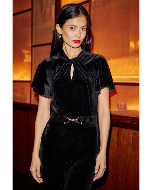 Yumi' Orange Velvet Jumpsuit With Twist Neckline And Buckle Belt