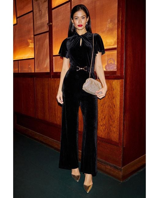 Yumi' Orange Velvet Jumpsuit With Twist Neckline And Buckle Belt