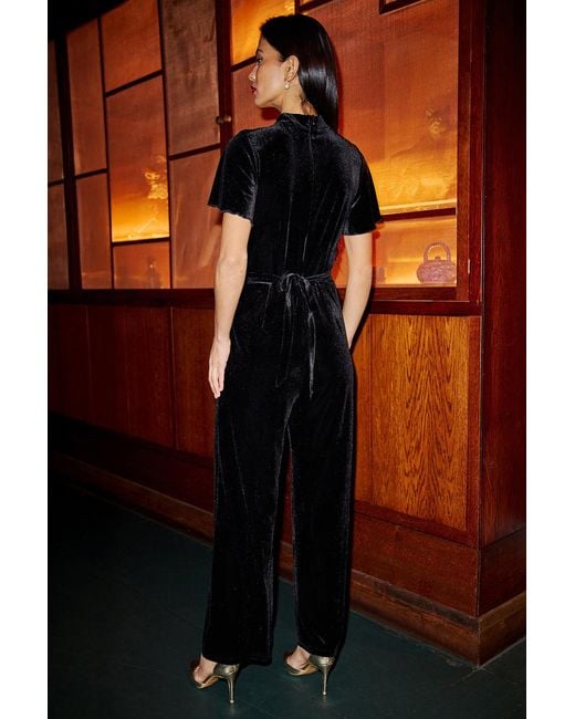 Yumi' Orange Velvet Jumpsuit With Twist Neckline And Buckle Belt