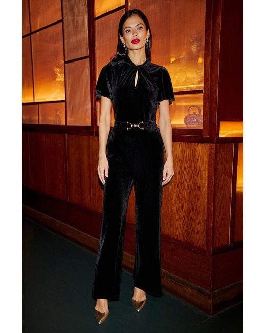Yumi' Orange Velvet Jumpsuit With Twist Neckline And Buckle Belt
