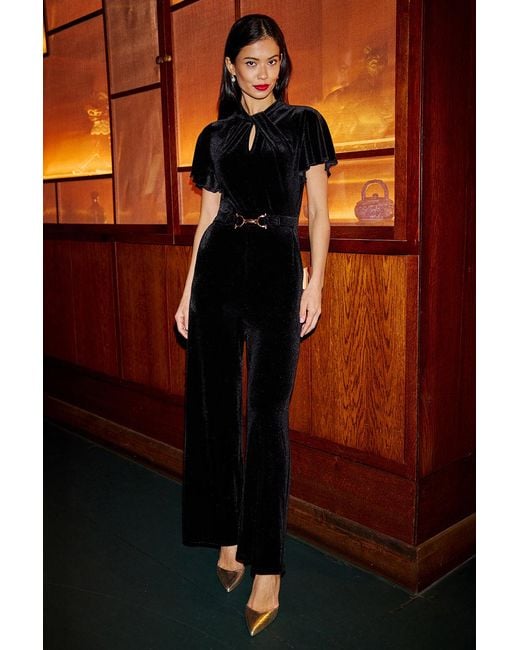 Yumi' Orange Velvet Jumpsuit With Twist Neckline And Buckle Belt